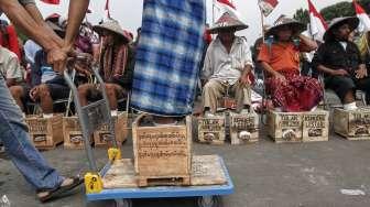 Puluhan petani dari kawasan Pegunungan Kendeng kembali melakukan aksi protes dengan mengecor kaki menggunakan semen di depan Istana Negara, Jakarta, Kamis (16/3/2017). [Suara.com/Kurniawan Mas'ud]