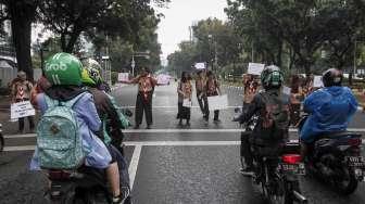 Aktivis Koalisi Pejalan Kaki dan Pramuka melakukan aksi peduli pejalan kaki di kawasan pedestrian Jalan Merdeka Selatan, Jakarta, Jumat (17/3).