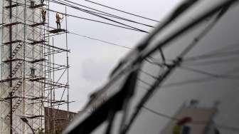 Pekerja melakukan perawatan gedung kantor pusat Pertamina, di Jakarta, Rabu (22/03).