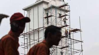 Pekerja melakukan perawatan gedung kantor pusat Pertamina, di Jakarta, Rabu (22/03).