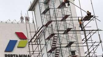 Pekerja melakukan perawatan gedung kantor pusat Pertamina, di Jakarta, Rabu (22/03).