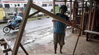 Pekerja menyelesaikan kerajinan kayu di sentra produksi kusen di kawasan Bukit Duri, Jakarta, Kamis (23/3).