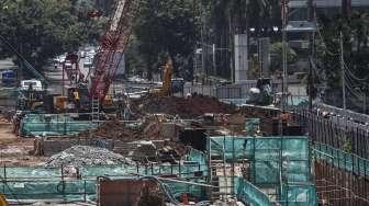 Pekerja menyelesaikan proyek pembangunan MRT di Jalan Jenderal Sudirman, Jakarta, Selasa (28/3/2017), di mana sementara itu posisi utang pemerintah tercatat naik Rp39,95 triliun dibanding Januari 2017. [Suara.com/Kurniawan Mas'ud]
