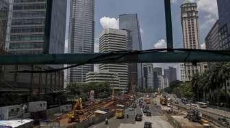 Pekerja menyelesaikan proyek pembangunan MRT di Jalan Jenderal Sudirman, Jakarta, Selasa (28/3/2017), di mana sementara itu posisi utang pemerintah tercatat naik Rp39,95 triliun dibanding Januari 2017. [Suara.com/Kurniawan Mas'ud]