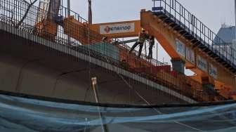 Sejumlah pekerja melanjutkan pengerjaan proyek jembatan Simpang Susun Semanggi, Jakarta, Selasa (4/4/2017), sembari memastikan terhindar dari kecelakaan kerja. [Suara.com/Kurniawan Mas'ud]