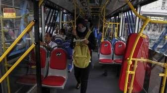 Penumpang menggunakan jasa Bus Transjakarta Maxi di Jakarta, Senin (10/4).