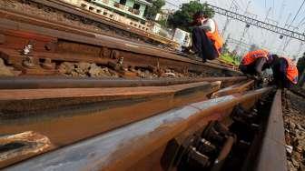 Pekerja mengecek rel kereta api di kawasan Stasiun Manggarai, di Jakarta, Kamis (13/4).