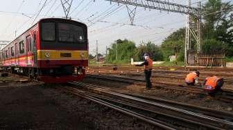 Pekerja mengecek rel kereta api di kawasan Stasiun Manggarai, di Jakarta, Kamis (13/4).