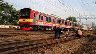 Pekerja mengecek rel kereta api di kawasan Stasiun Manggarai, di Jakarta, Kamis (13/4).