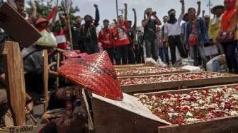 Sejumlah petani korban konflik lahan di Telukjambe Karawang, Jawa Barat, menggelar aksi kubur diri di depan Istana Negara, Jakarta, Selasa (25/4/2017). [Suara.com/Kurniawan Mas'ud]