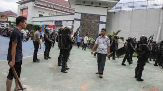 Petugas kepolisian berpakaian sipil dibantu warga menangkap tahanan yang kabur dari Rutan Sialang Bungkuk Kelas IIB, Pekanbaru, Riau, Jumat (5/5).