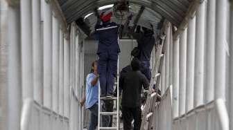 Petugas melakukan perbaikan atap kanopi halte  Transjakarta di Pancoran Barat, Jakarta, Kamis (11/5).