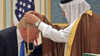 Presiden Amerika Serikat (AS) Donald Trump saat dikalungi medali Order of Abdulaziz al-Saud oleh Raja Arab Saudi Salman bin Abdulaziz al-Saud di Pengadilan Kerajaan Saudi di Riyadh, Sabtu (20/5/2017). [Mandel Ngan/AFP]