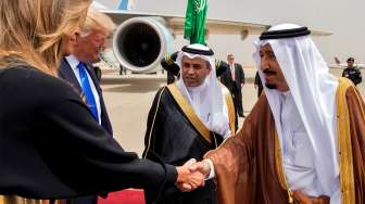 Raja Arab Saudi Salman bin Abdulaziz al-Saud menyalami Ibu Negara Amerika Serikat (AS) Melania Trump saat tiba di Bandara Internasional Raja Khalid di Riyadh, Sabtu (20/5/2017). [Bandar al-Jaloud/Saudi Royal Palace/AFP]