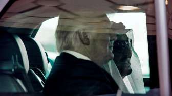 Tampak Presiden Amerika Serikat (AS) Donald Trump dan Raja Arab Saudi Salman bin Abdulaziz al-Saud naik mobil bersama setelah disambut di Bandara Internasional Raja Khalid, Sabtu (20/5/2017). [Bandar al-Jaloud/Saudi Royal Palace/AFP]