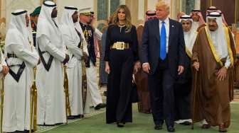 Presiden Amerika Serikat (AS) Donald Trump dan istrinya Melania Trump didampingi Raja Arab Saudi Salman bin Abdulaziz al-Saud, saat tiba di Pengadilan Kerajaan Saudi di Riyadh, Sabtu (20/5/2017). [Bandar al-Jaloud/Saudi Royal Palace/AFP]