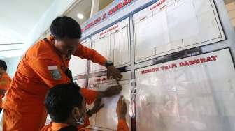 Petugas SAR menempelkan lokasi peta pencarian di Posko Evakuasi KM Mutiara Sentosa I di Gapura Surya Nusantara, Pelabuhan Tanjung Perak, Surabaya, Jawa Timur, Sabtu (20/5/2017). [Antara/Didik Suhartono]