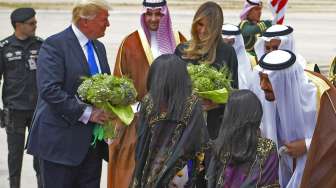 Presiden AS Donald Trump dan istrinya Melania Trump disambut bunga saat diterima Raja Arab Saudi Salman bin Abdulaziz al-Saud yang didampingi putranya Khaled bin Salman, di Bandara Internasional Raja Khalid, Sabtu (20/5/2017). [Mandel Ngan/AFP]