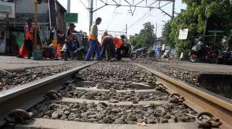 Pekerja memperbaiki jalur rel kereta api yang ambles di jalur KRL Manggarai-Sudirman di Jakarta, Selasa (23/5/2017). [Suara.com/Oke Atmaja]