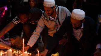 Masyarakat menyalakan lilin dan berdoa di kawasan Albert Square, Manchester, sebagai aksi solidaritas bagi korban aksi bom bunuh diri di Manchester Arena, Senin (22/5/2017) malam. (AFP)