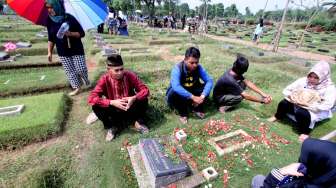 Sejumlah peziarah membaca doa di depan pusara makam di Pemakaman Umum Pondok Rangon, Jakarta Timur, Kamis (25/5/2017), sebagai bagian dari tradisi menjelang bulan suci Ramadan. [Antara/Yulius Satria Wijaya]