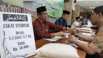 Warga melakukan proses pembayaran zakat fitrah melalui lembaga amil zakat di Masjid Istiqlal, Jakarta, Kamis (22/6/2017). [Suara.com/Oke Atmaja]