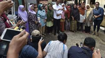 Presiden Joko Widodo membagikan paket sembako kepada warga di kawasan Duri Kepa, Jakarta, Kamis (22/6).