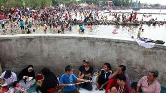 Pengunjung bermain di Pantai Ancol, Jakarta, Rabu (28/6). (Suara.com/Oke Atmaja)