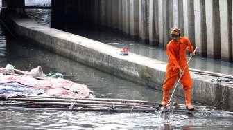 Petugas Dinas Kebersihan DKI Jakarta membersihkan sampah di Kali Tanah Abang, Jakarta, Jumat (30/6).