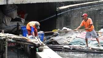 Petugas Dinas Kebersihan DKI Jakarta membersihkan sampah di Kali Tanah Abang, Jakarta, Jumat (30/6).