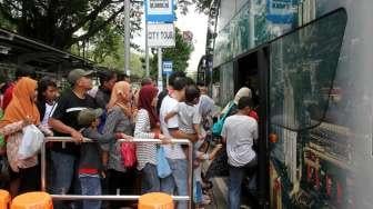 Warga mengantre untuk naik bus tingkat keliling Jakarta di Halte Lapangan IRTI, Jakarta, Sabtu (1/7).