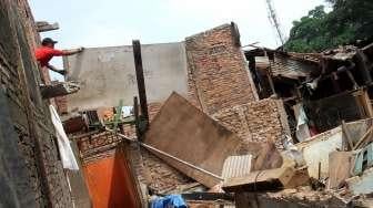 Warga melakukan pembongkaran bangunan miliknya masing-masing di wilayah bantaran Sungai Ciliwung, Bukit Duri, Jakarta, Sabtu (8/7/2017). [Suara.com/Oke Atmaja]