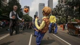 Empat boneka asal Prancis dari Kelompok teater Les Grandes Personnes hibur warga saat berlangsungnya Car Free Day (CFD) di Jakarta, Minggu (9/7). [Suara.com/Kurniawan Mas'ud]