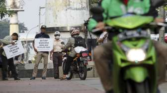 Koalisi Pejalan Kaki melakukan aksi menghadang pengendara sepeda motor yang melintas di trotoar di kawasan Casablanca, Jakarta, Jumat (21/7).