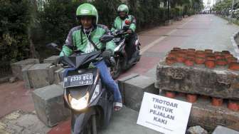 Koalisi Pejalan Kaki melakukan aksi menghadang pengendara sepeda motor yang melintas di trotoar di kawasan Casablanca, Jakarta, Jumat (21/7).