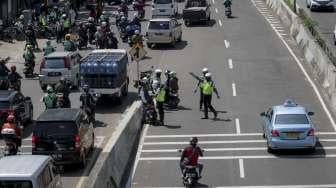 Polisi melakukan penindakan kepada pengendara sepeda motor yang melanggar larangan melintas di jalan layang non tol Casablanca, Jakarta Selatan, Rabu (26/7/2017). [Suara.com/Kurniawan Mas'ud]