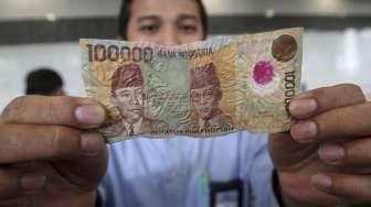 Petugas memperlihatkan contoh uang kertas Rupiah yang tidak layak edar di loket Gedung C Bank Indonesia, Jakarta, Rabu (26/7/2017). [Suara.com/Kurniawan Mas'ud]