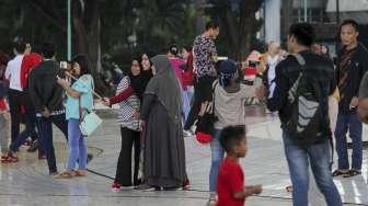 Pengunjung wisata Taman Mini Indonesia Indah (TMII) di Jakarta, Minggu (30/7).