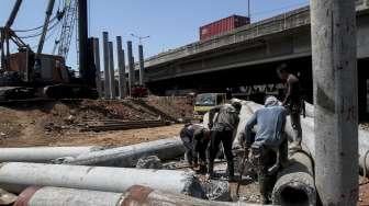 Pekerja menyelesaikan pembangunan proyek jalan tol Seksi E2 dengan rute Cilincing-Jampea, di Jakarta, Senin (28/8).