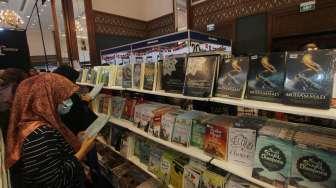 Pengunjung tampka mengamati sejumlah buku yang dijual pada salah satu stan Indonesia International Book Fair di Jakarta Convention Center (JCC), Jakarta, Sabtu (9/9/2017). [Suara.com/Oke Atmaja]