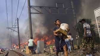 Warga berusaha menyelamatkan harta bendanya dari lokasi kebakaran di Kampung Bandan, Jakarta, Sabtu (16/9).