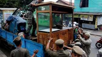 Petugas Satpol PP ketika bertugas melakukan penertiban pedagang kaki lima (PKL) di sepanjang trotoar kawasan Stasiun Manggarai, Jakarta, Senin (18/9/2017). [Suara.com/Oke Atmaja]