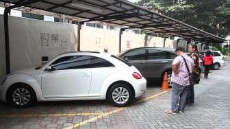 Calon peserta lelang mengecek kondisi mobil hasil sitaan kasus korupsi di Gedung KPK, Jakarta, Selasa (19/9).