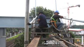 Pekerja menyelesaikan pembangunan jembatan penyeberangan orang (JPO) di sekitar Stasiun Tanjung Barat, Jakarta, Jumat (29/9).