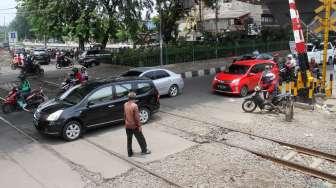 Sejumlah kendaraan melintas di perlintasan kereta api di Jalan KH Hasyim Ashari, Cideng, Jakarta, Minggu (1/10).