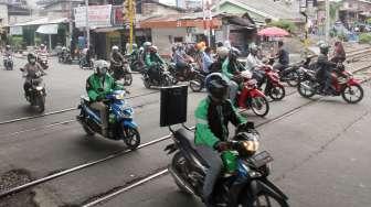 Sejumlah kendaraan melintas di perlintasan kereta api di Jalan KH Hasyim Ashari, Cideng, Jakarta, Minggu (1/10).