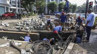 Petugas Suku Dinas Sumber Daya (SDA) Jakarta Pusat membuat sodetan untuk saluran di Jalan KH Wahid Hasyim, Kebon Sirih, Jakarta, Selasa (3/10).