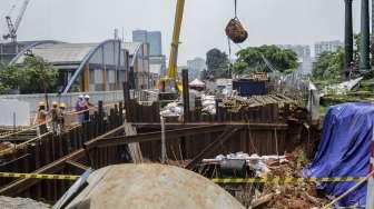 Pekerja LRT memasang terpal plastik untuk menutup area bekas amblas di depan gedung Menara Saidah, Jalan MT. Haryono, Jakarta, Jumat (13/10).