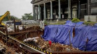 Pekerja LRT memasang terpal plastik untuk menutup area bekas amblas di depan gedung Menara Saidah, Jalan MT. Haryono, Jakarta, Jumat (13/10).