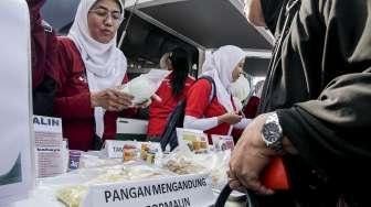 Petugas Balai POM saat kampanye jenis makanan dan obat-obatan dalam acara Aksi Nasional Pemberantasan Obat Ilegal dan Penyalahgunan Obat kepada para pengunjung di kawasan Car Free Day (CFD), Jakarta, Minggu (22/10/2017). [Suara.com/Kurniawan Mas'ud]